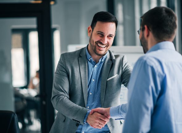 Portrait of cheerful young manager handshake with new employee.