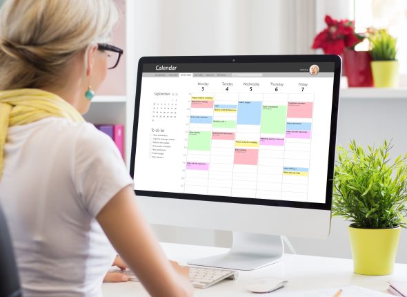 Woman using calendar app on computer in office