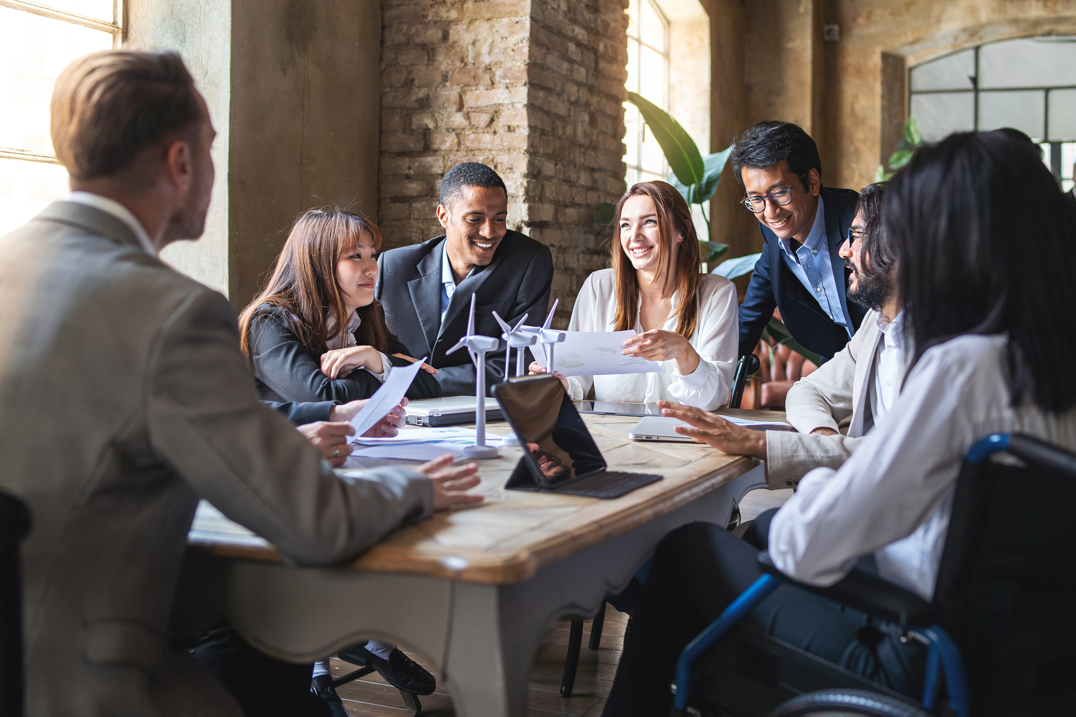 Group of multiethnic businesspeople discussing about financial strategy, renewable power, sustainable innovation project and environmental economical issues - business, sustainability interracial lifestyle concept