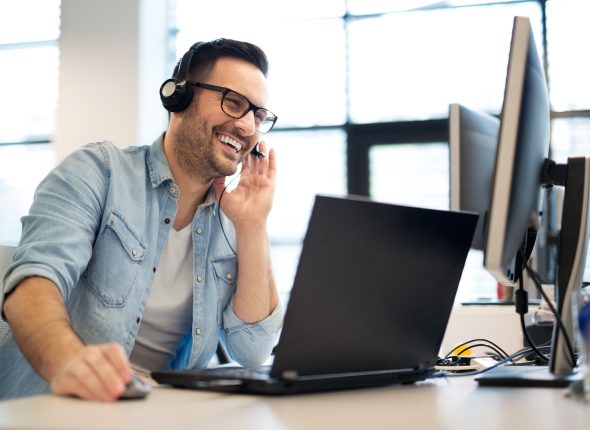 Young smiling male call center operator doing his job with a hea