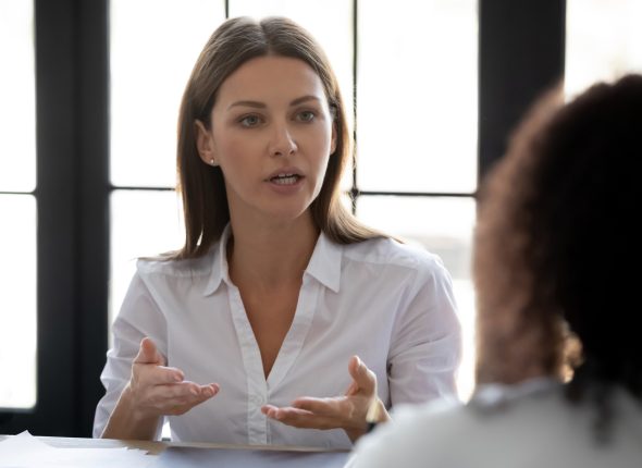 Close up confident serious businesswoman talking with business partner.