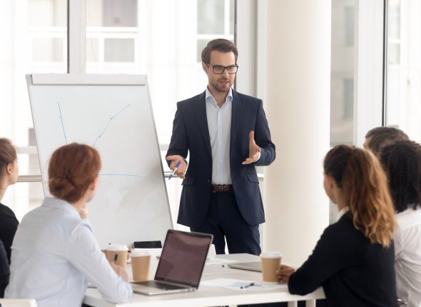 Male business coach speaker in suit give flipchart presentation