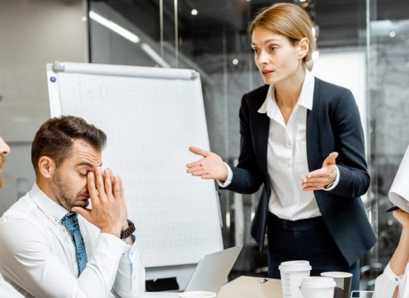 Boss quarreling at employees during a conference